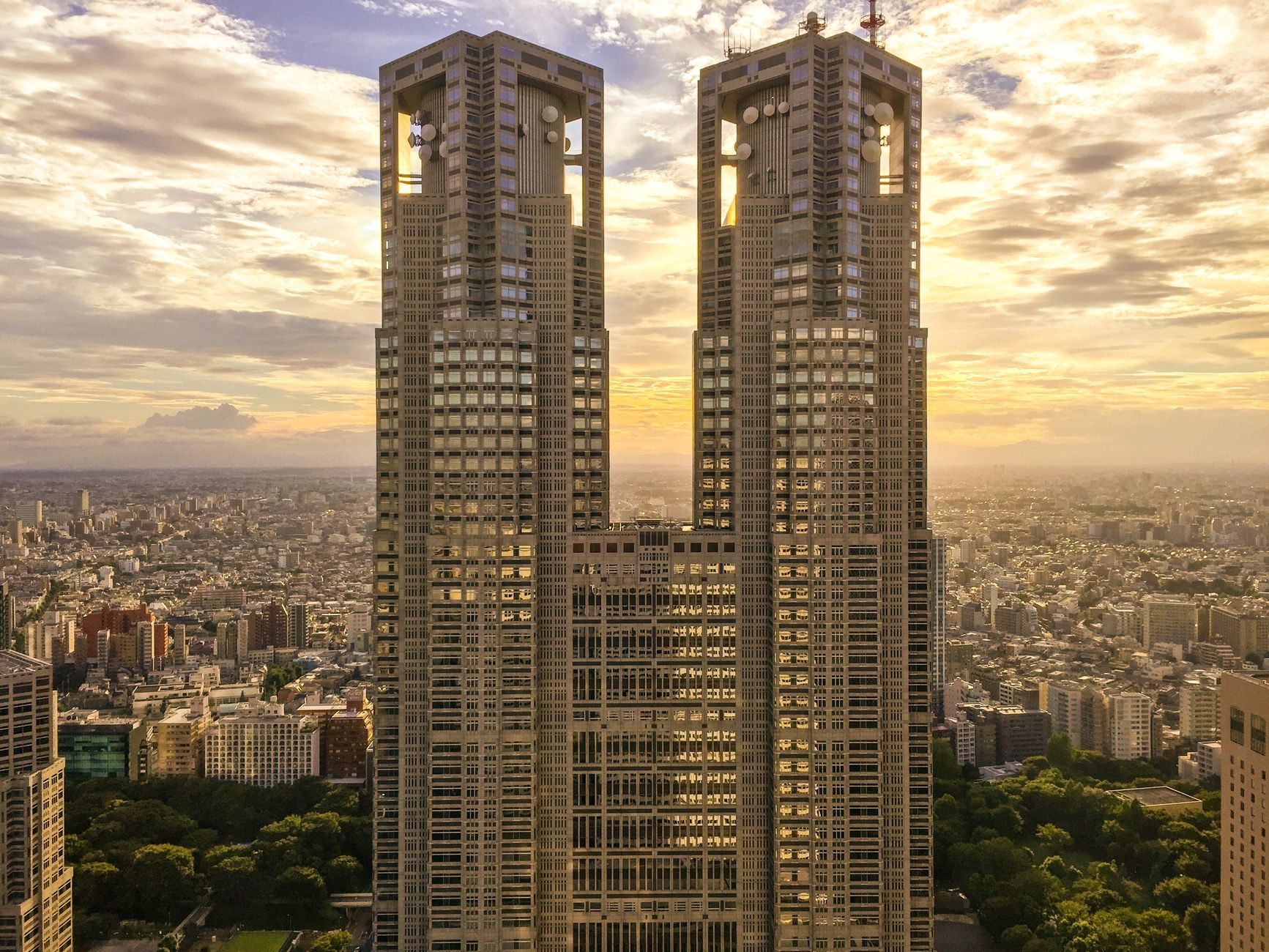 Aerial view of Tokyo's skyline at sunset featuring the Tokyo Metropolitan Government Building.