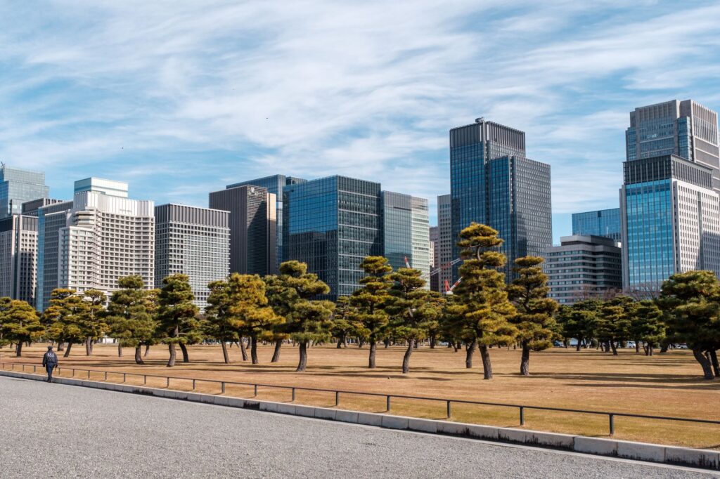 Urban landscape of Tokyo's skyline with modern skyscrapers and green trees for a cityscape contrast.