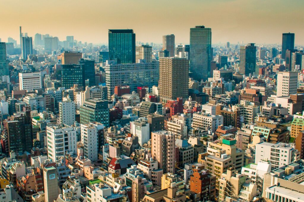 Aerial view of Tokyo skyline with diverse high-rise buildings under a warm daylight.