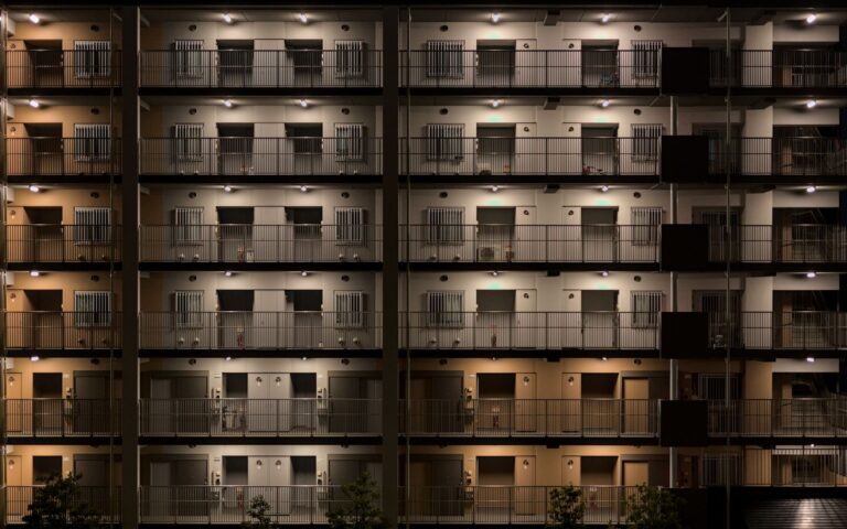 A symmetrical view of an illuminated apartment building in Kyoto at night.
