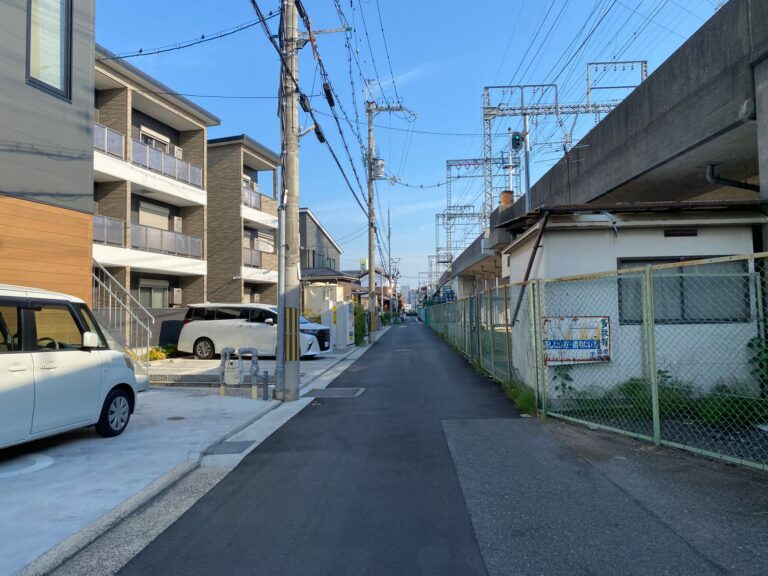 Peaceful suburban street in Osaka, Japan with modern houses and vibrant blue sky.