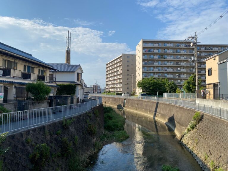 Urban residential scene with apartments near a river in Ikeda, Osaka, Japan.