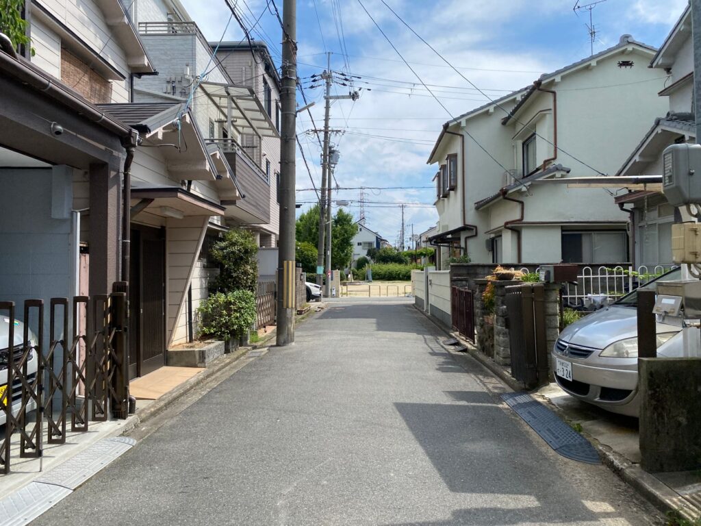Calm residential street in a suburban area with clear blue sky and typical houses.