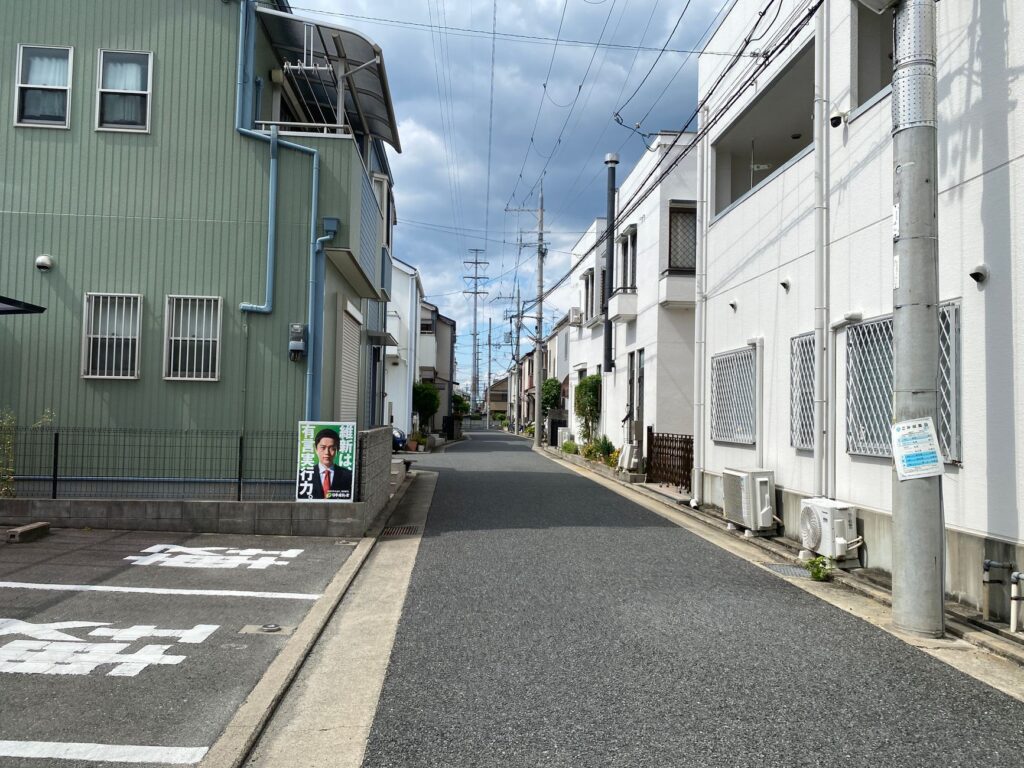 A serene residential street in a Japanese neighborhood under a cloudy sky.