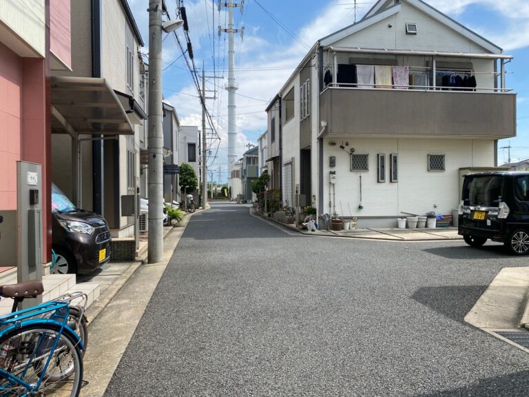 Calm urban scene showing modern houses along a quiet street on a sunny day.