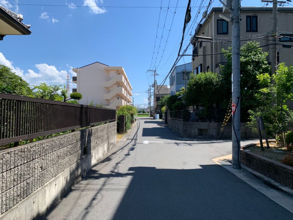 Quiet suburban street under a clear blue sky on a sunny day.