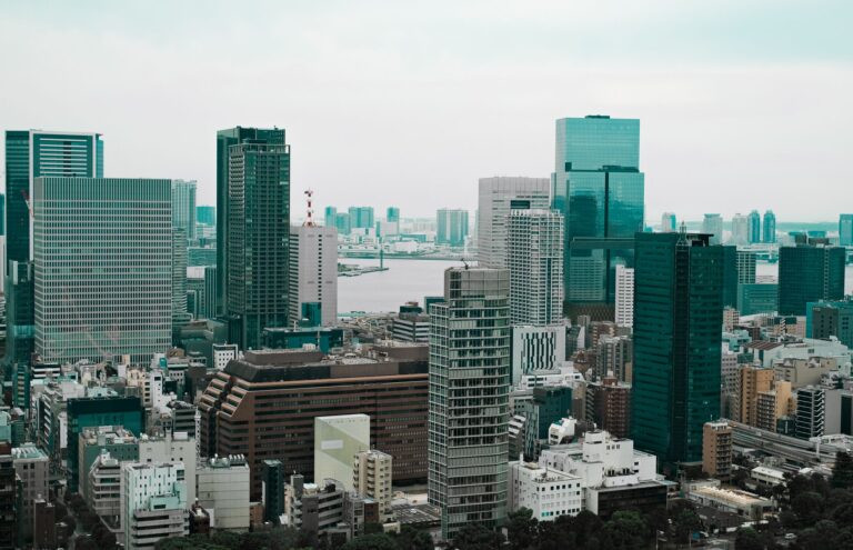 Aerial view of Tokyo's modern skyscrapers with a river backdrop, showcasing urban architecture.