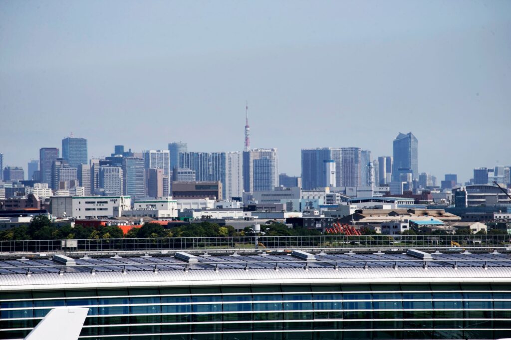 Aerial view of Tokyo skyscrapers with Tokyo Tower visible, showcasing urban architecture.