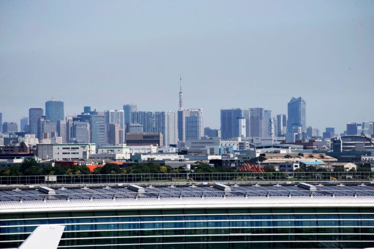Aerial view of Tokyo skyscrapers with Tokyo Tower visible, showcasing urban architecture.
