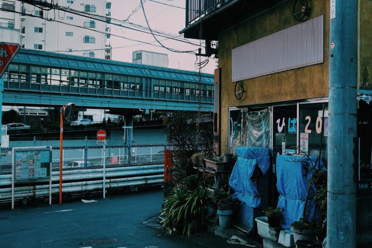 Urban scene in Tokyo showcasing street with building and overpass, capturing city life and architecture.
