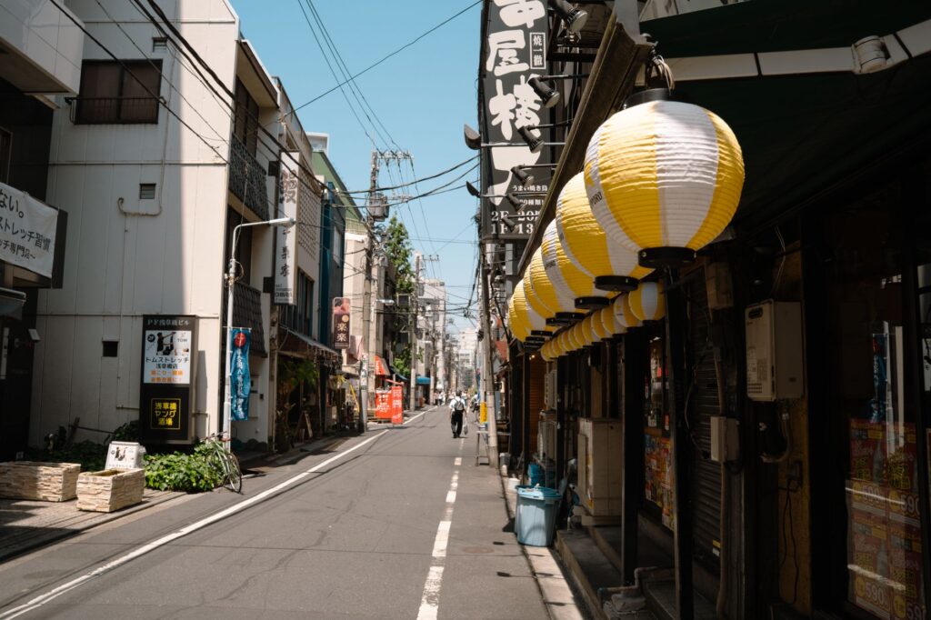 Charming Tokyo street view with decorative lanterns on a sunny day.