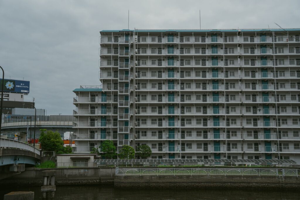 Multi-story residential building beside a canal in Tokyo, Japan, showcasing urban architecture.