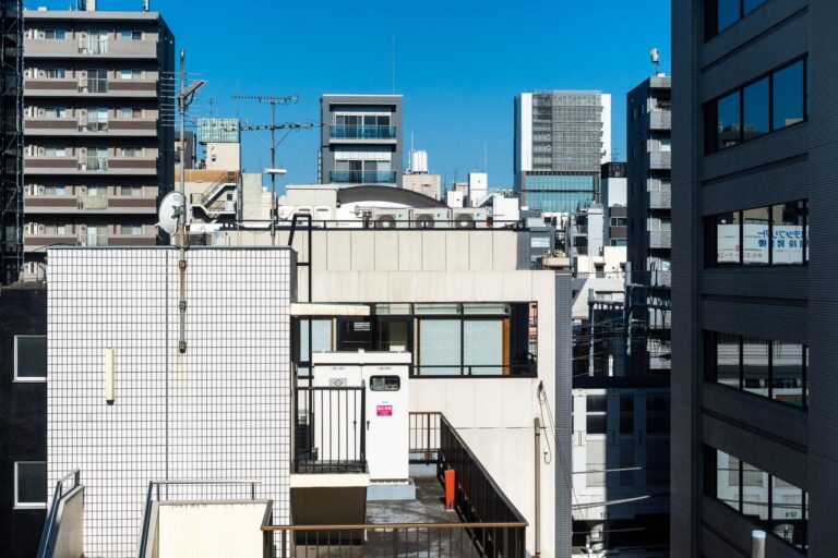 Modern buildings under a clear blue sky in Taito City, Tokyo, Japan.