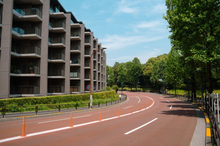 Curved street view with modern residential buildings in Tokyo, surrounded by lush greenery.