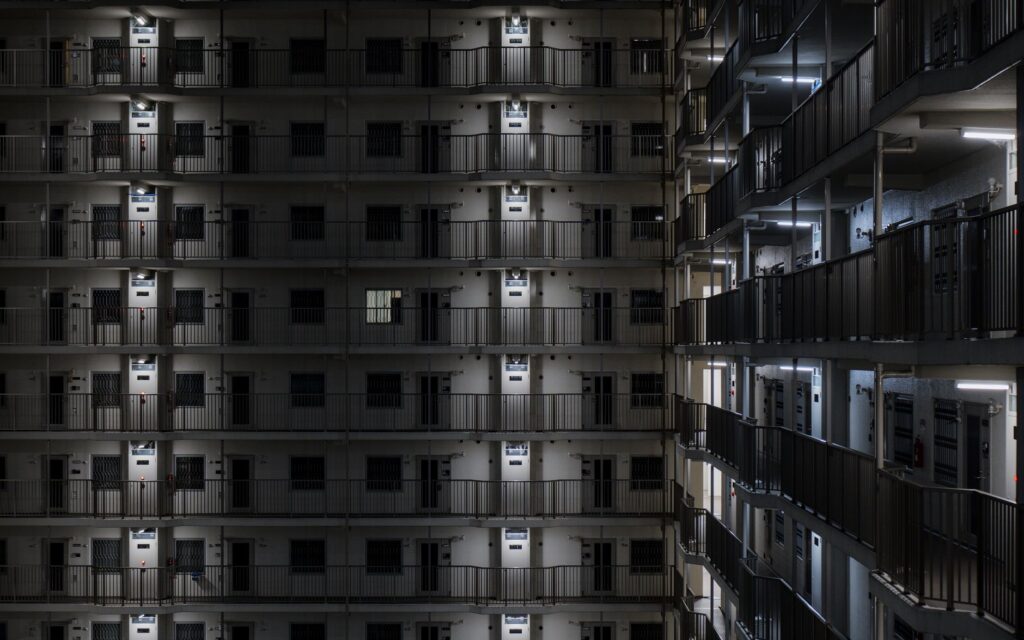 Illuminated view of a modern apartment building facade in Kyoto at night.