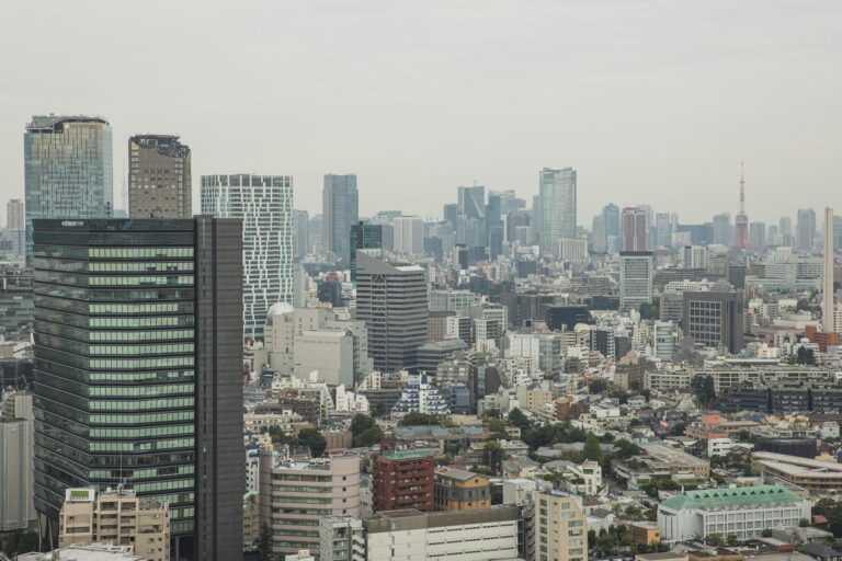 Aerial view of modern city with glass skyscrapers and multistory buildings in overcast weather
