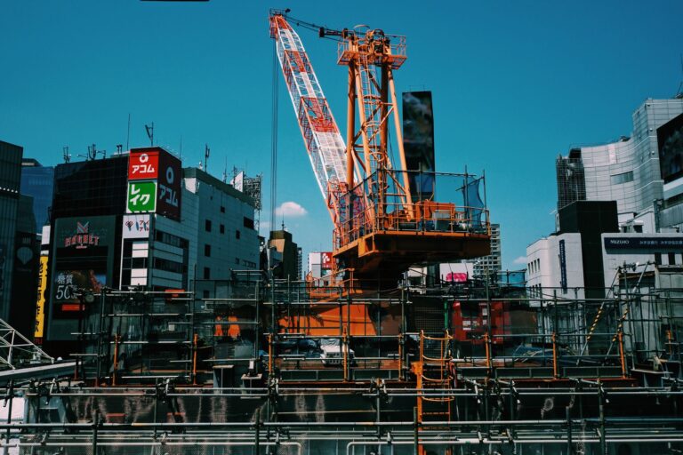 Vibrant cityscape with crane and scaffolding in Tokyo, Japan, under clear skies.