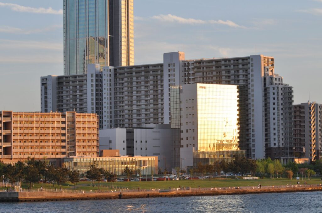 Contemporary cityscape featuring high-rise buildings and waterfront park during sunset.
