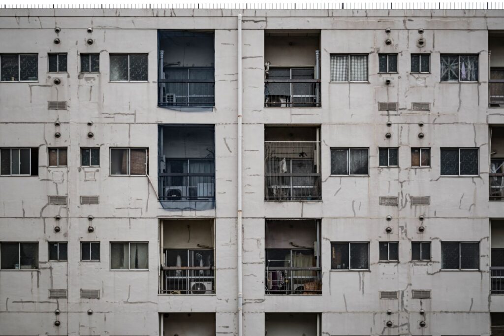 Close-up of a worn apartment building facade in Osaka, highlighting urban architecture.
